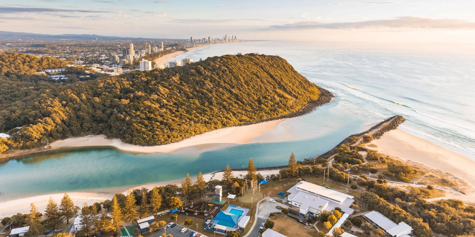 Tallebudgera Creek meeting the sea beside the Burleigh headland, from the air at golden hour