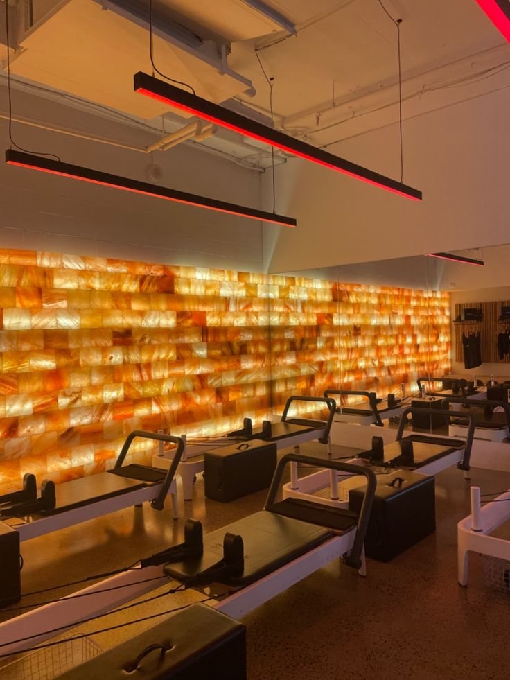 Reformer machines in front of a glowing salt-brick wall at CHANGE Broadbeach
