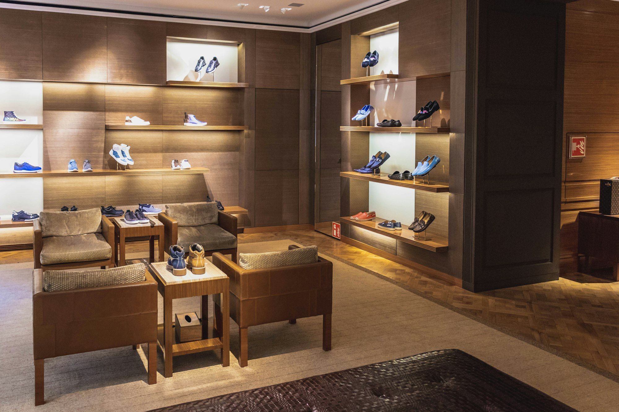 Leather goods on shelves and tables in a softly lit boutique