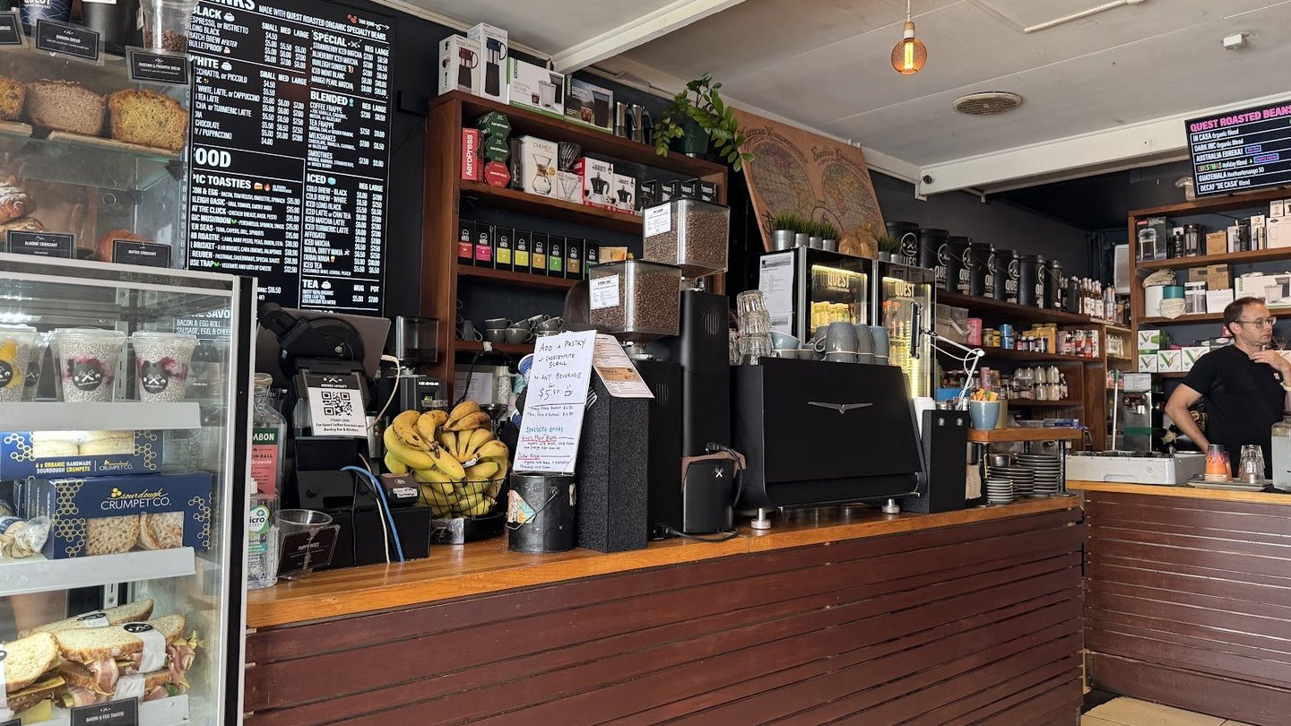 The coffee counter, menu boards and shelves inside Quest Coffee Roasters