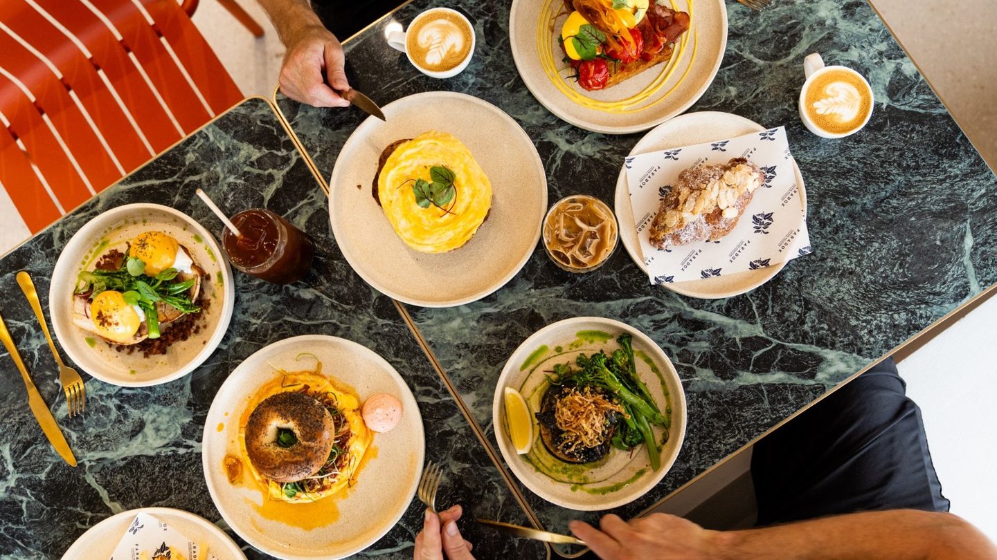Brunch dishes and coffees on a marble table at Paradox Coffee Roasters
