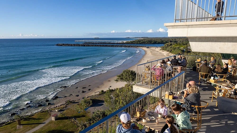Diners on the deck at Black Dingo Café, above the beach at Point Danger