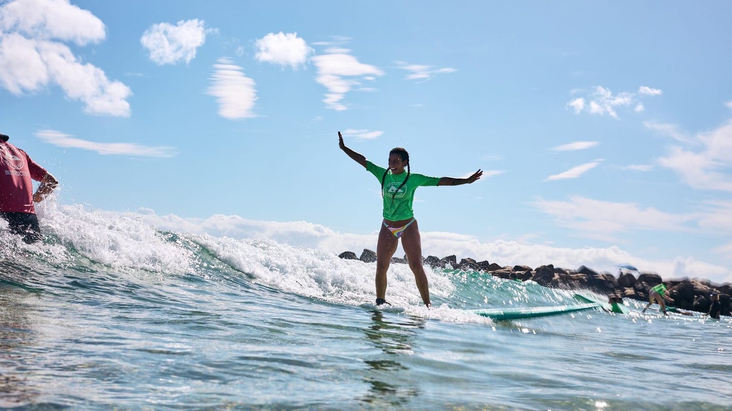 A Currumbin Alley Surf School student riding a wave