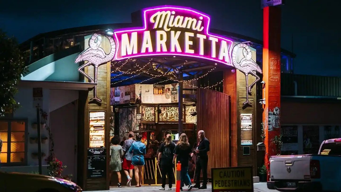The neon Miami Marketta sign over the entrance at night