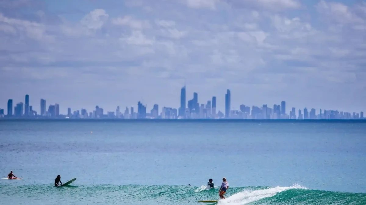 Surfers at Kirra, with the Gold Coast skyline across the water
