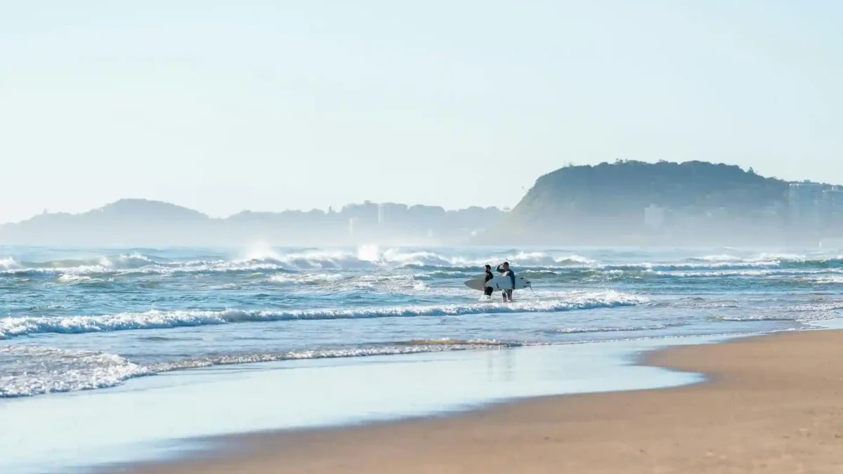 Surfers heading into the waves at Mermaid Beach