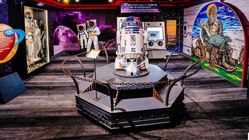 A space-themed gallery at Ripley's, with astronaut suits and a droid on a platform