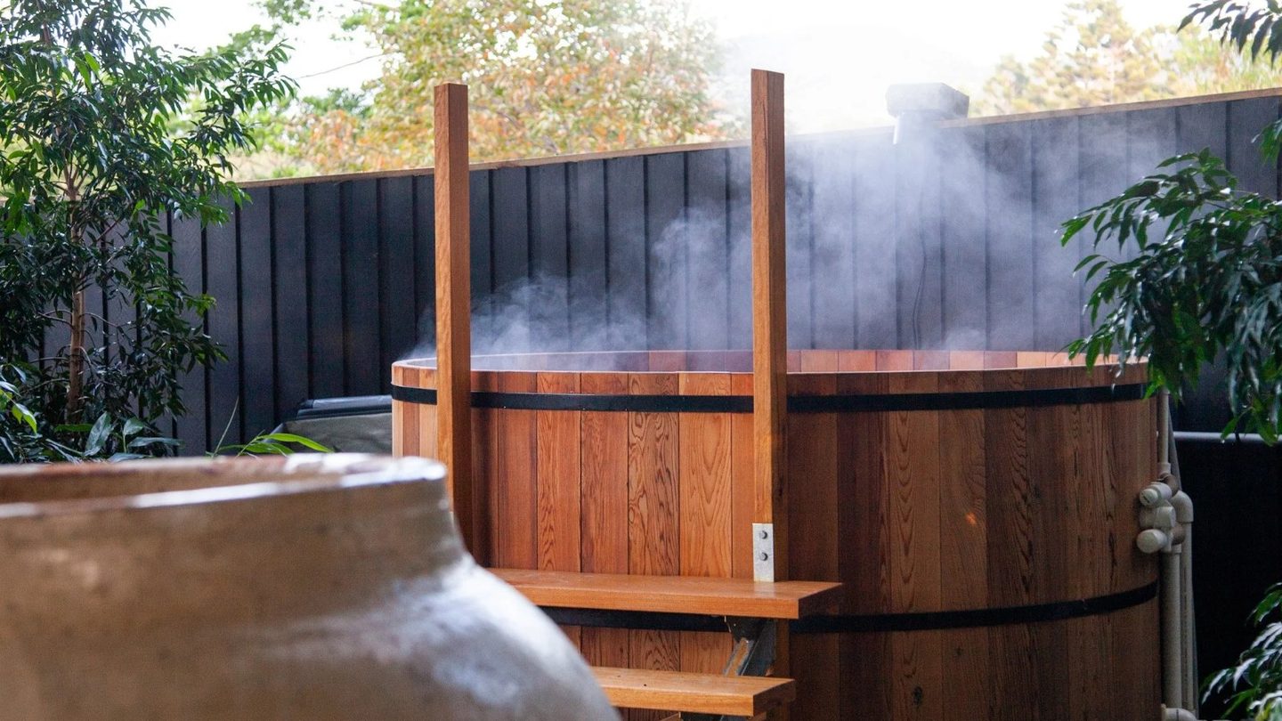 A steaming cedar hot tub at The Bathhouse at Ground