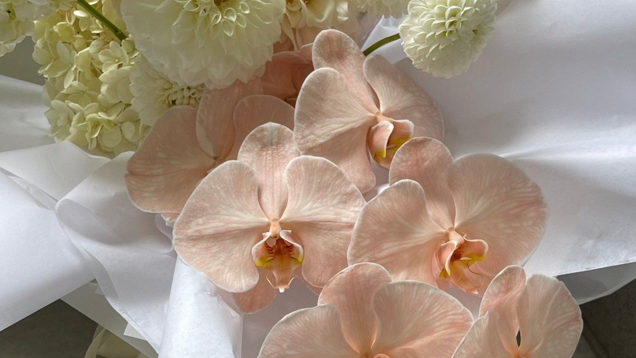 Peach orchids and white blooms in a Flower Bar Co. bouquet