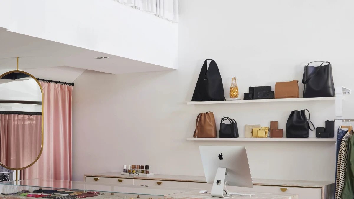 Handbags on white shelves inside Camargue, which stocks Romance Was Born