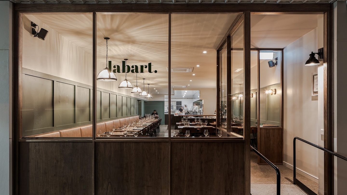 The glass front of Restaurant Labart, with its name on the back wall