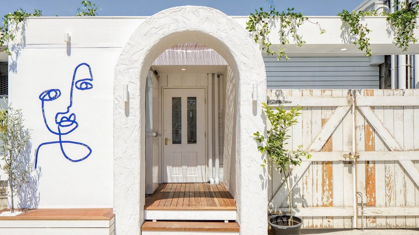 Maman's white arched entrance, with a line-drawn face on the wall