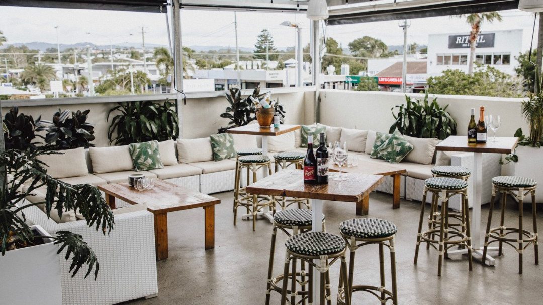 White lounges and tables on the rooftop at The Collective Palm Beach