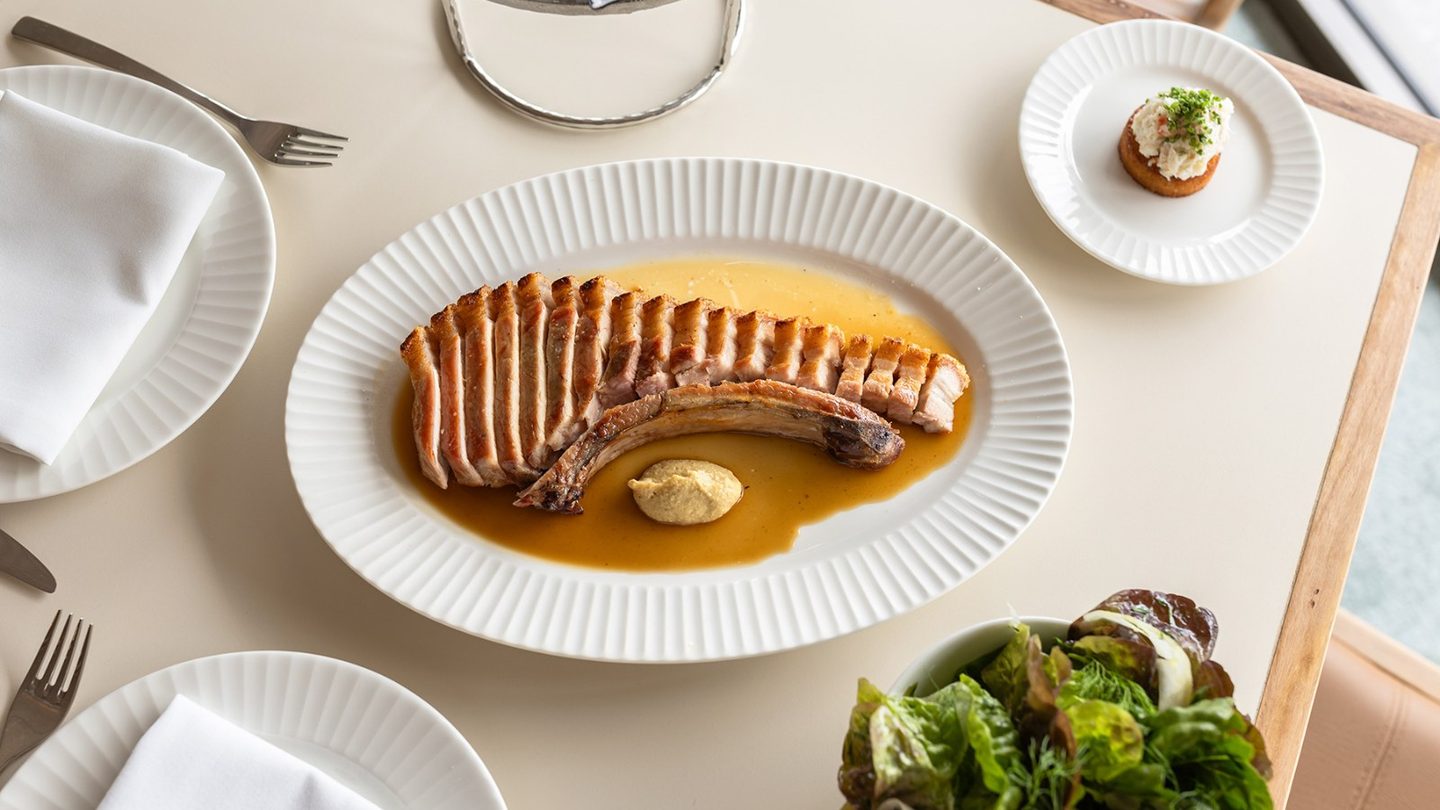 A wood-fired pork chop and salads at Lars Bar & Grill