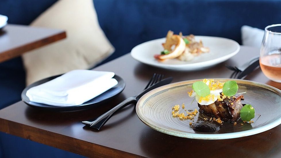 Plated dishes on a dark table at The North Room