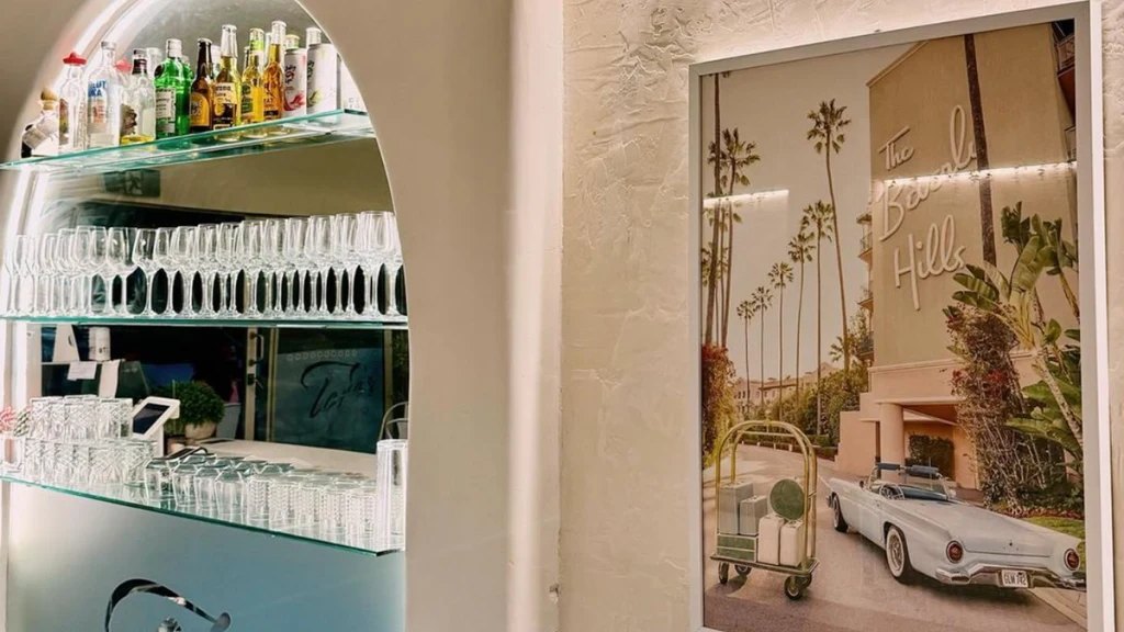 Glassware on a shelf beside a mural of palms and a vintage car at Toro's Pizza
