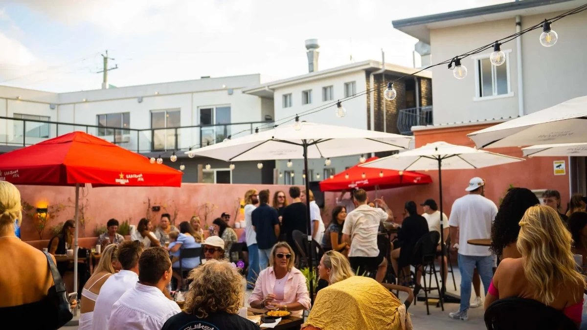 Crowded tables under red and white umbrellas at Lucia Tapas
