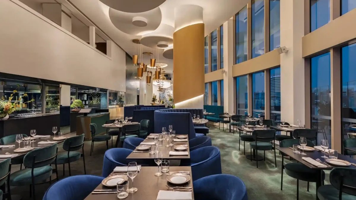 Nineteen's dining room, with tall windows and blue velvet chairs