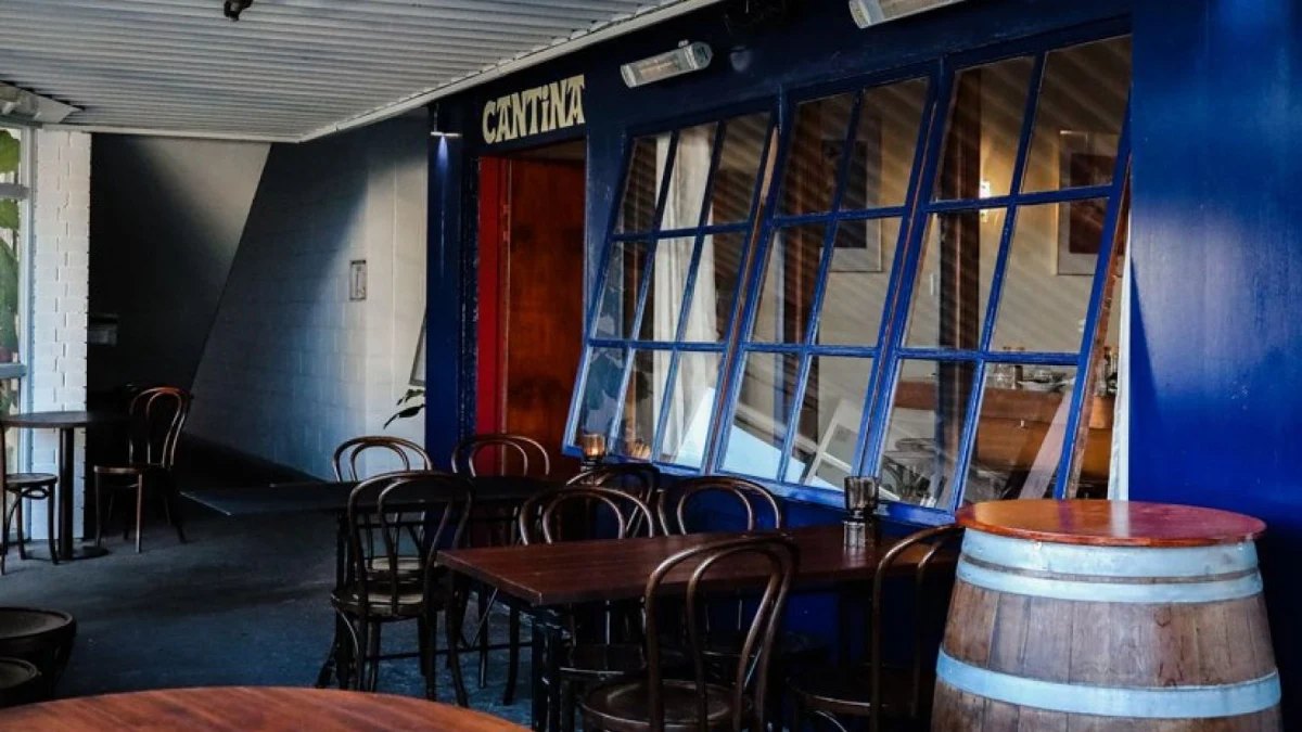 Timber tables and a wine barrel inside Cantina