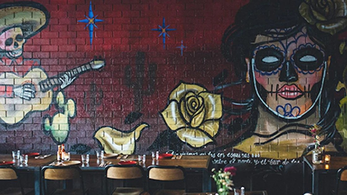 A Day of the Dead mural above the tables at Bonita Bonita