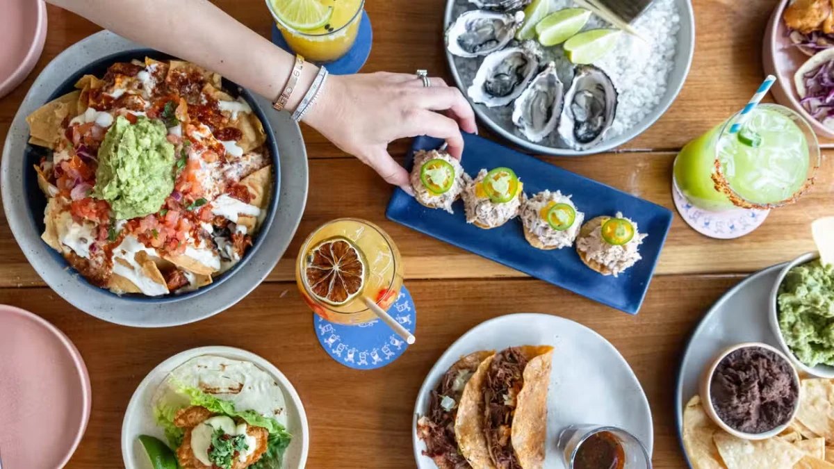 Nachos, tacos, oysters and margaritas on a table at Mexicali