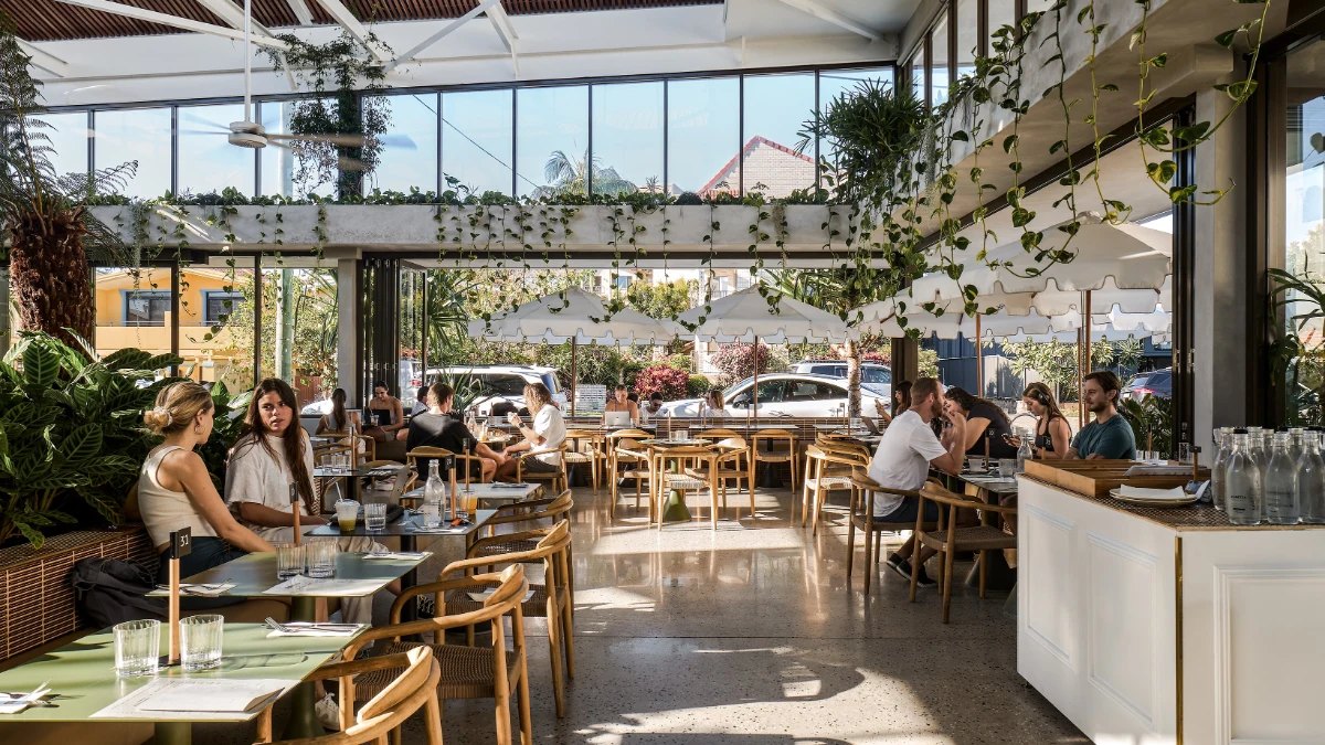 The glass-roofed atrium at The Oxley 1823, with diners among the plants