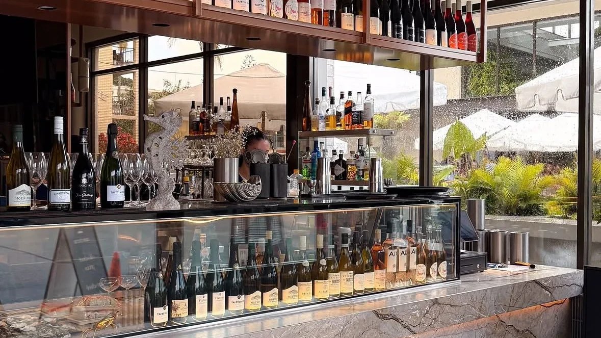 Wine bottles and glasses behind the bar at Eska Sea Merchants