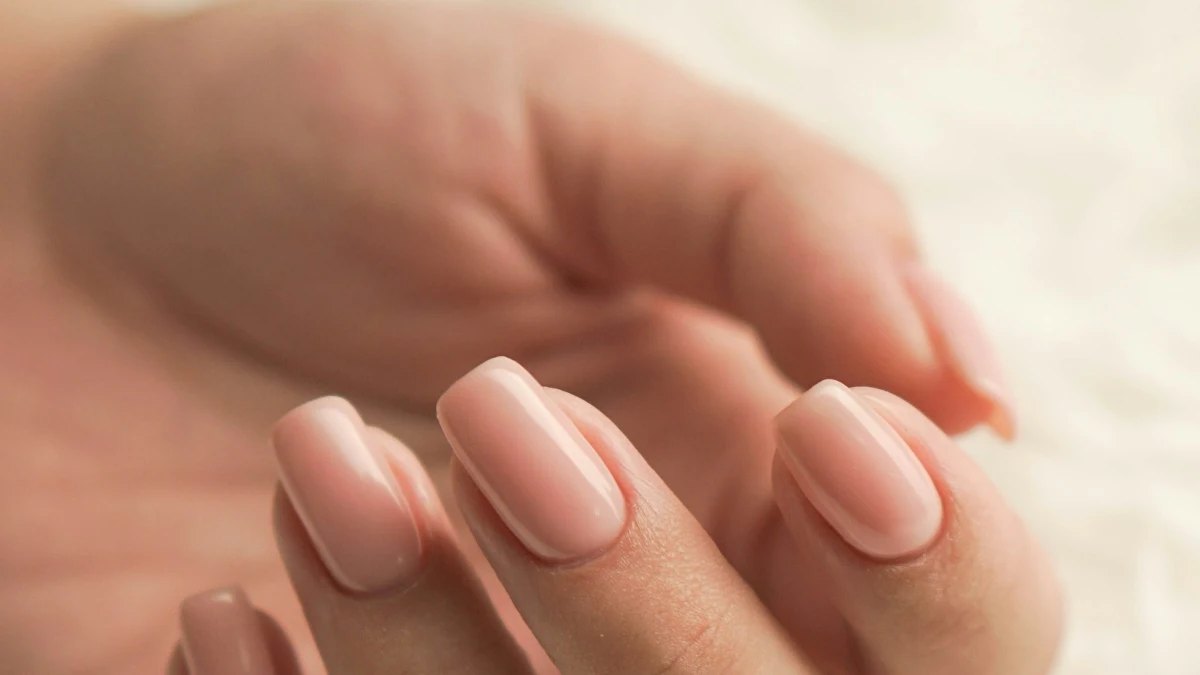 A hand with freshly manicured pale pink nails